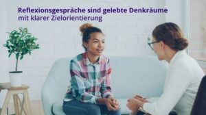 Zwei Frauen sitzen sich in einem ruhigen Gespräch gegenüber. Im Bild steht der Text: „Reflexionsgespräche sind gelebte Denkräume mit klarer Zielorientierung.“